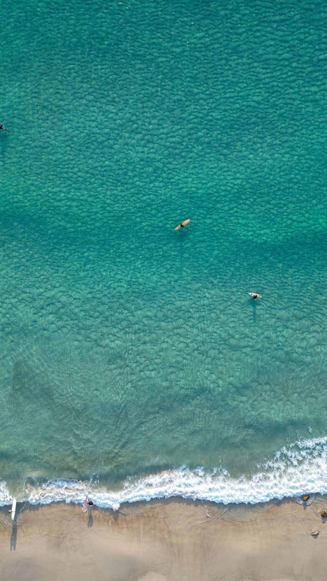 Aerial of surfers on turquoise water
